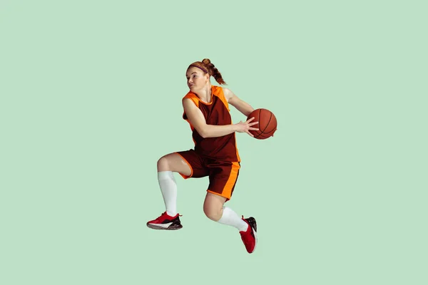 年轻的高加索女篮球运动员与薄荷色工作室背景的对比 — 图库照片