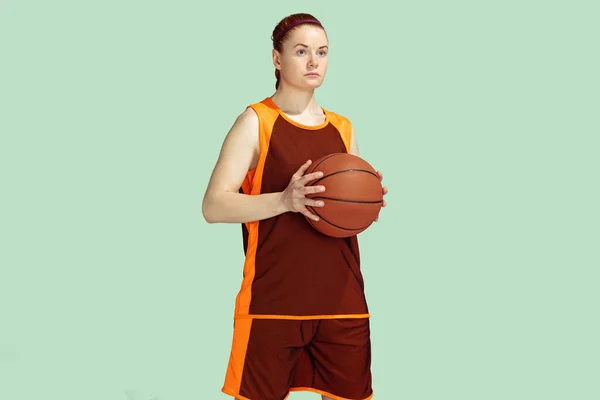 Ung kaukasisk kvinnlig basketspelare mot mynta färgade studio bakgrund — Stockfoto