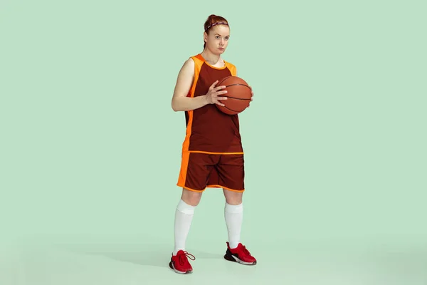 Pemuda kaukasia pemain basket wanita terhadap latar belakang studio berwarna mint — Stok Foto