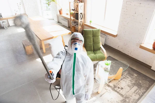 Coronavirus pandemi. Desinfektionsmedel i skyddsdräkt och masksprej desinfektionsmedel i huset eller på kontoret — Stockfoto