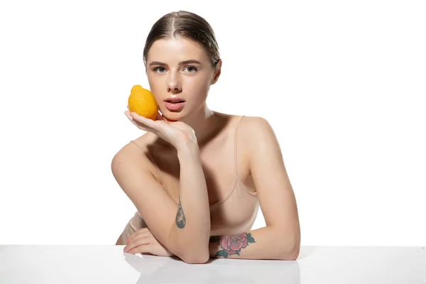 Jugoso. Hermosa joven con fondo naranja sobre blanco. Cosméticos y maquillaje, tratamiento natural y ecológico, cuidado de la piel . — Foto de Stock