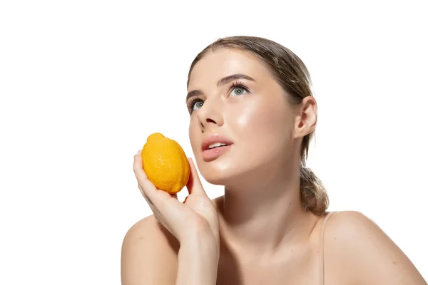 Όνειρα. Όμορφη νεαρή γυναίκα με πορτοκαλί πάνω από λευκό φόντο. Καλλυντικά και μακιγιάζ, φυσική και οικολογική θεραπεία, περιποίηση δέρματος. — Φωτογραφία Αρχείου