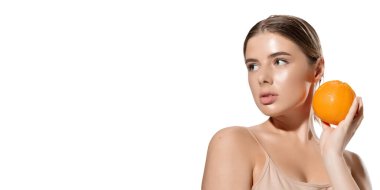 Parılda. Beyaz arka planı turuncu olan güzel bir genç kadın. Kozmetik ve makyaj, doğal ve ekolojik tedavi, cilt bakımı. El ilanı.