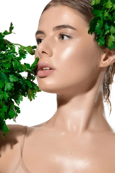 Vitaminler. Yüzünde yeşil yapraklar olan, beyaz arka planda güzel genç bir bayana yakın durun. Kozmetik ve makyaj, doğal ve eko tedavi, cilt bakımı — Stok fotoğraf