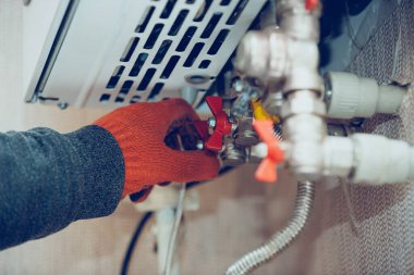 Erkek el gaz şişesinin fitilini kapatır, ısıtıcı, akışı keser.