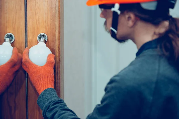 Electricista reemplazar la lámpara. Primer plano del hombre reparando una lámpara. Concepto peligroso, alto voltaje, riesgo, reemplazo de cableado, ocupación de técnicos — Foto de Stock