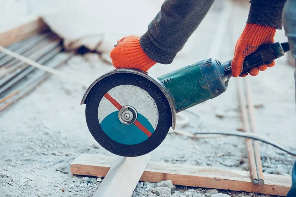 Close-up de mãos de reparador, construtor profissional trabalhando ao ar livre, corta moedor — Fotografia de Stock