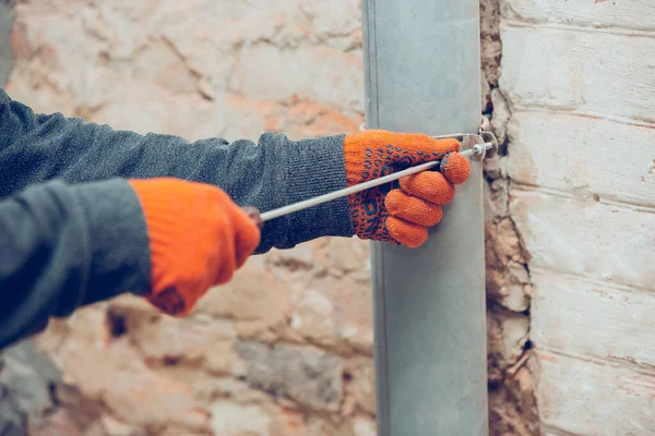 Nahaufnahme der Hände von Reparateuren, professionellen Bauarbeitern, die in Innenräumen arbeiten, verlegt Kanäle, Kanäle — Stockfoto