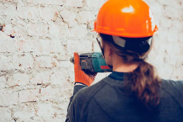 Großaufnahme der Hände eines Reparateurs, professioneller Bauarbeiter, der in Innenräumen arbeitet, bohrt eine Wand — Stockfoto