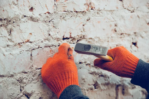 Primer plano de las manos del reparador, constructor profesional trabajando en interiores, martillo un tacón con un tornillo en la pared —  Fotos de Stock