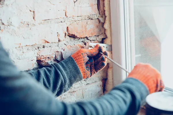 Nahaufnahme der Hände des Reparateurs, professioneller Bauarbeiter, der im Haus arbeitet, installiert Fenster — Stockfoto