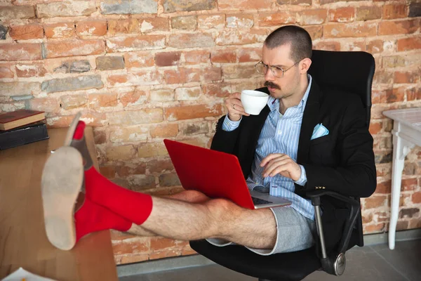 Young man without pants but in jacket working on a computer, laptop. Remote office during coronavirus, fun and comfortable work in underpants — Stock Photo, Image