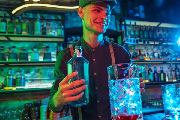 Barman propone cócteles alcohólicos, tragos, bebidas a los huéspedes en luz de neón multicolor — Foto de Stock