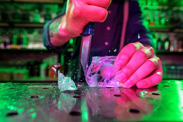 Nahaufnahme vom Barmann, der ein großes Stück Eis auf der Theke zerkleinert, auf der eine spezielle Bar-Ausrüstung für einen Cocktail steht — Stockfoto