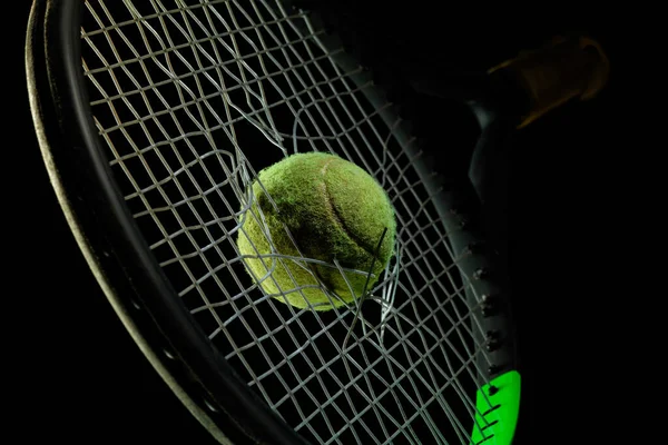 Professional sport equipment isolated on black studio background. Tennis racket and ball.