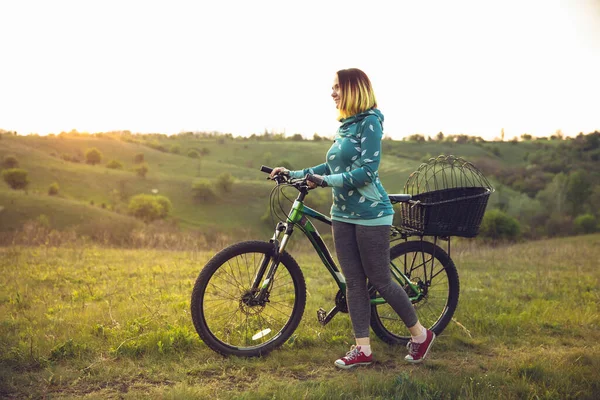 Młoda kobieta bawiąca się w pobliżu parku krajobrazowego, jazda na rowerze, podróże w wiosenny dzień — Zdjęcie stockowe