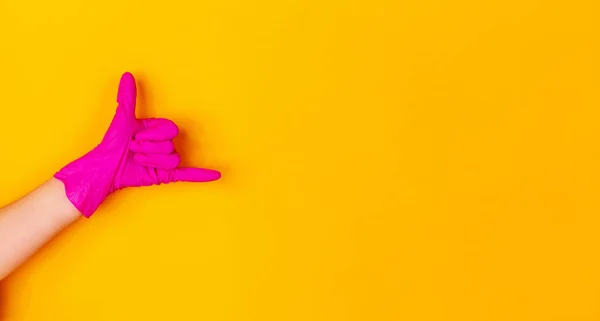 Guante de mano de goma rosa aislado sobre fondo estudio amarillo con copyspace. Volante . — Foto de Stock