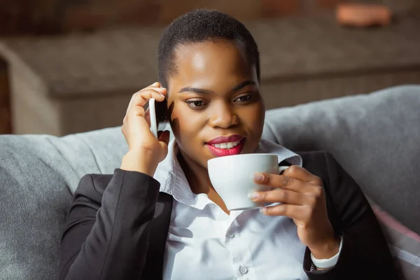 Afroamerikansk affärskvinna i kontorskläder ler, ser självsäker och glad, framgångsrik — Stockfoto