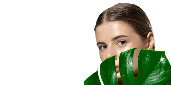 Biologisch. Close-up van mooie jonge vrouw met groene bladeren over witte achtergrond. Cosmetica en make-up, natuurlijke en eco-behandeling, huidverzorging. Flyer met copyspace. — Stockfoto