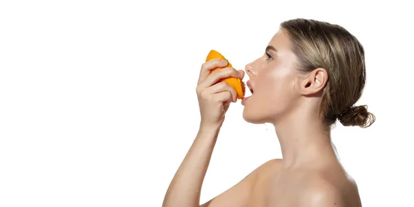 Енергія. Крупним планом красива молода жінка кусає соковитий апельсин на білому тлі. Косметика та макіяж, природне та екологічне лікування, догляд за шкірою. Флаєр, пропозиція . — стокове фото
