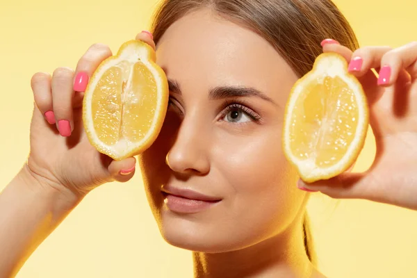 Close up de belo rosto feminino com fatias de limão sobre fundo amarelo. Cosméticos e maquiagem, tratamento natural e ecológico, cuidados com a pele . — Fotografia de Stock
