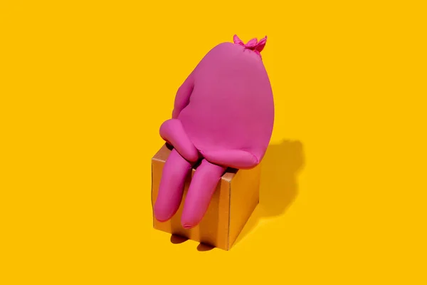 Liv i gummihandske som en person - beskyttende slid isoleret på gul studiebaggrund - Stock-foto