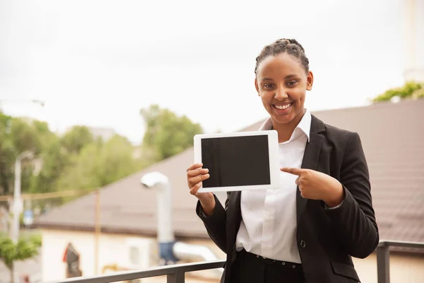 Mujer de negocios afroamericana en traje de oficina sonriendo, se ve confiada y feliz, exitosa —  Fotos de Stock