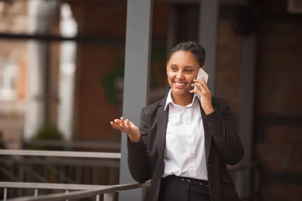 Mujer de negocios afroamericana en traje de oficina sonriendo, se ve confiada y feliz, exitosa —  Fotos de Stock