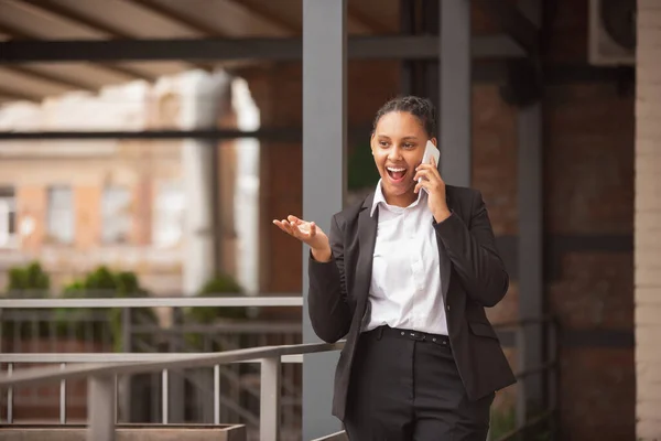 Mujer de negocios afroamericana en traje de oficina sonriendo, se ve confiada y feliz, exitosa —  Fotos de Stock