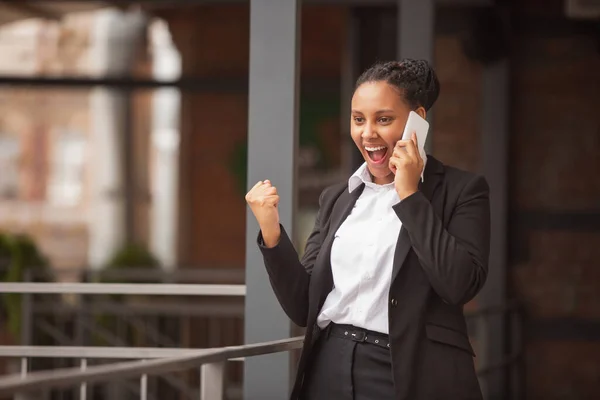 Empresária afro-americana em traje de escritório sorrindo, parece confiante e feliz, bem sucedida — Fotografia de Stock