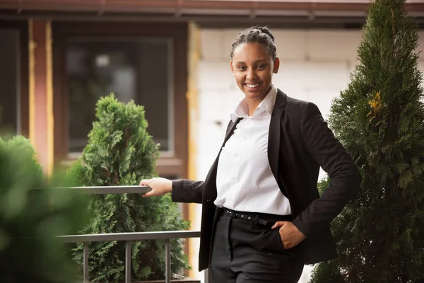 Empresária afro-americana em traje de escritório sorrindo, parece confiante e feliz, bem sucedida — Fotografia de Stock