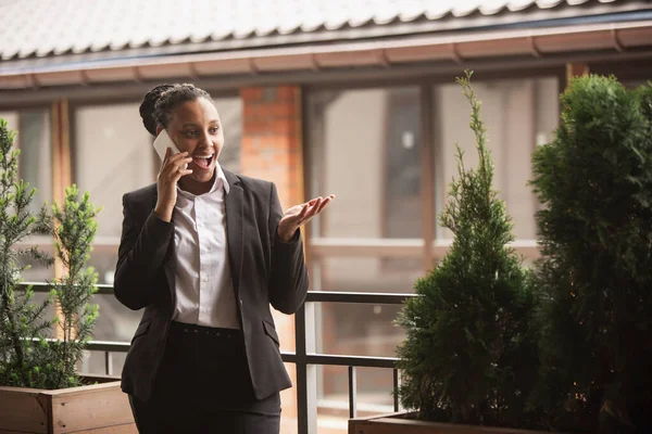 Mujer de negocios afroamericana en traje de oficina sonriendo, se ve confiada y feliz, exitosa —  Fotos de Stock