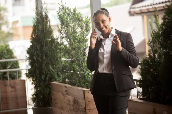 Empresária afro-americana em traje de escritório sorrindo, parece confiante e feliz, bem sucedida — Fotografia de Stock