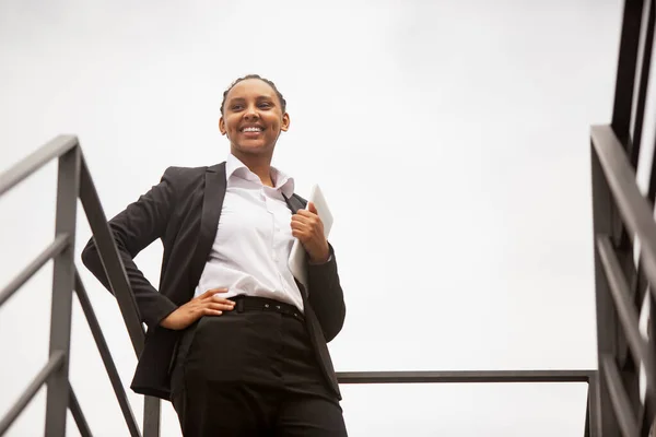 Empresária afro-americana em traje de escritório sorrindo, parece confiante e feliz, bem sucedida — Fotografia de Stock