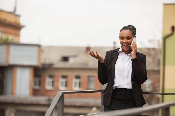 Empresária afro-americana em traje de escritório sorrindo, parece confiante e feliz, bem sucedida — Fotografia de Stock