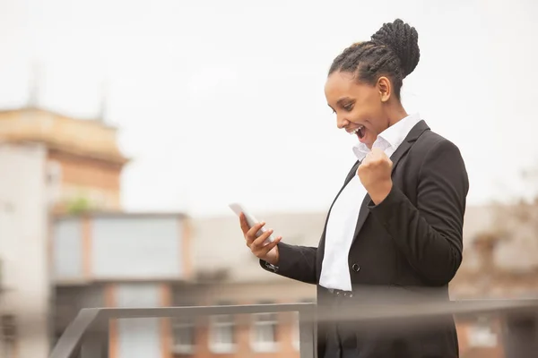 Mujer de negocios afroamericana en traje de oficina sonriendo, se ve confiada y feliz, exitosa —  Fotos de Stock