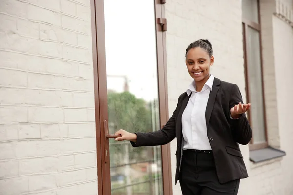 Mujer de negocios afroamericana en traje de oficina sonriendo, se ve confiada y feliz, exitosa —  Fotos de Stock