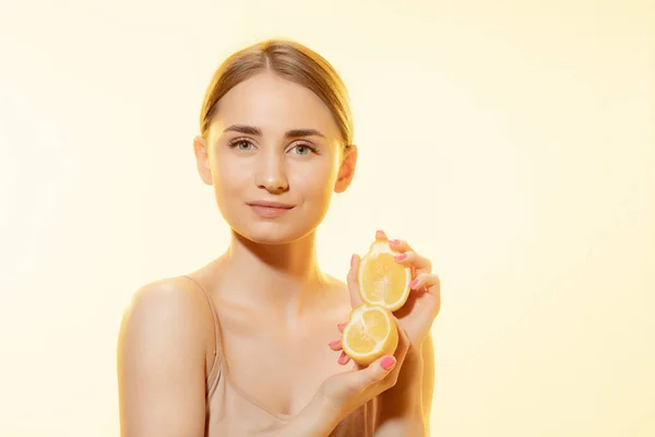 Citrus. Sarı arka planda limon dilimleri olan güzel kadın yüzünü kapat. Kozmetik ve makyaj, doğal ve eko tedavi, cilt bakımı. — Stok fotoğraf
