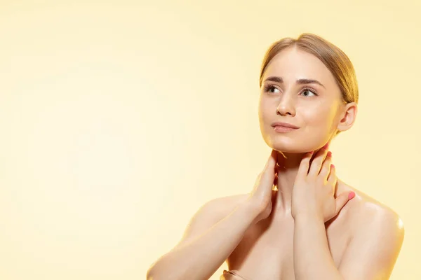 Gevoelige huid. Close-up van mooie vrouw met moisturizer over gele achtergrond. Cosmetica en make-up, natuurlijke en eco-behandeling, huidverzorging. — Stockfoto