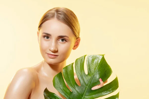 Spa. Close up de belo rosto feminino com folhas verdes sobre fundo branco. Cosméticos e maquiagem, tratamento natural e ecológico, cuidados com a pele . — Fotografia de Stock