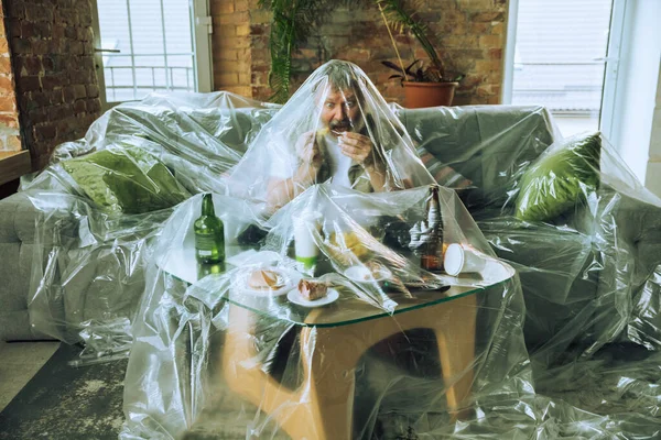 Homem idoso coberto de plástico, comer fast food e beber cerveja - poluição ambiental pelo conceito de pessoas — Fotografia de Stock