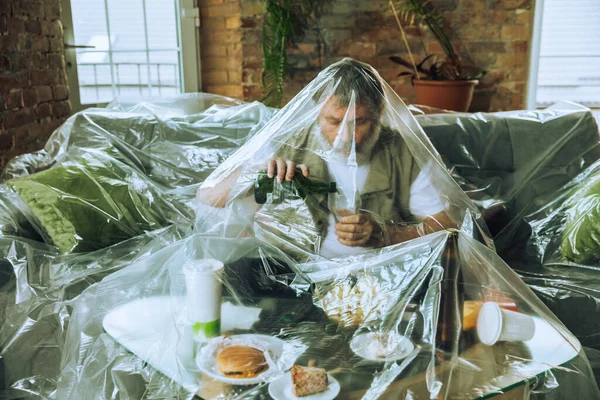 Homem idoso coberto de plástico, comer fast food e beber cerveja - poluição ambiental pelo conceito de pessoas — Fotografia de Stock