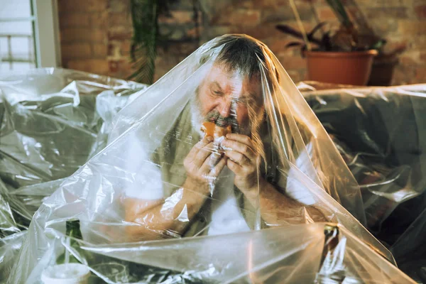 Homem idoso coberto de plástico, comer fast food e beber cerveja - poluição ambiental pelo conceito de pessoas — Fotografia de Stock