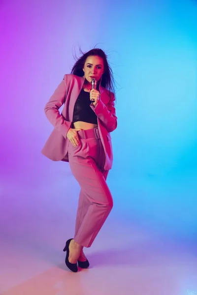 Retrato femenino de cantante caucásica aislado en el fondo del estudio de gradiente en luz de neón —  Fotos de Stock