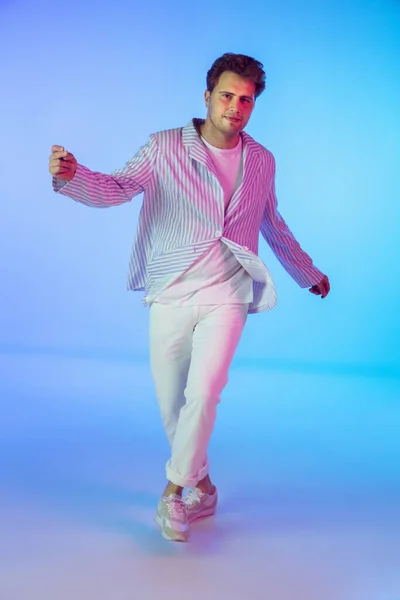 Jovem músico caucasiano, dançarino, apresentador de festa, DJ em fundo gradiente em luz de néon — Fotografia de Stock