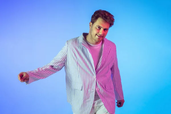 Fiatal kaukázusi zenész, táncos, party host, DJ gradiens háttér neon fény — Stock Fotó