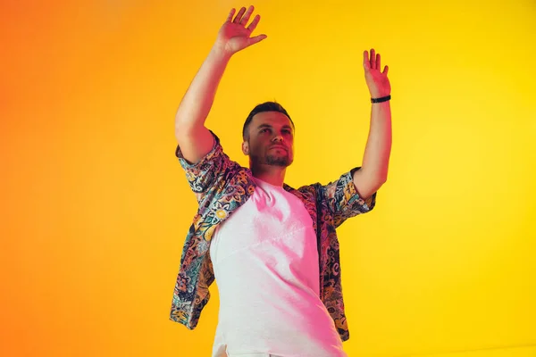 Jovem músico caucasiano, dançarino, apresentador de festa, DJ em fundo gradiente em luz de néon — Fotografia de Stock