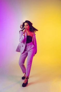 Beyaz kadın şarkıcı portresi neon ışıklı arka planda izole edilmiş.