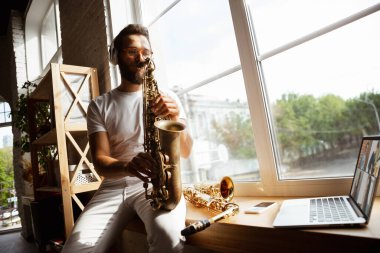 Evdeki konserde saksafon çalan beyaz müzisyen tecrit edilmiş ve karantinaya alınmış, internete bağlı grupla etkileyici bir doğaçlama.