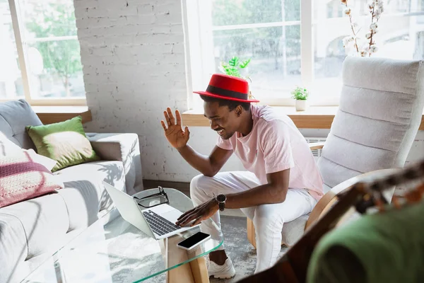 Afroamerikaner während eines Videocalls mit seiner Band zu Hause sitzend, Musiker während Quarantäne und Isolierung — Stockfoto